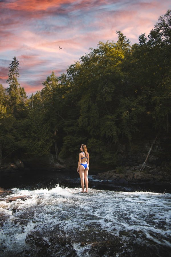 Girl in blue 2 piece bathing suit on a river rapid